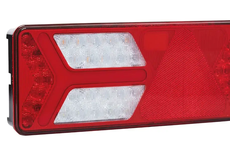 Red polycarbonate tail light lens with clear backup light sections showing textured plastic surface patterns 