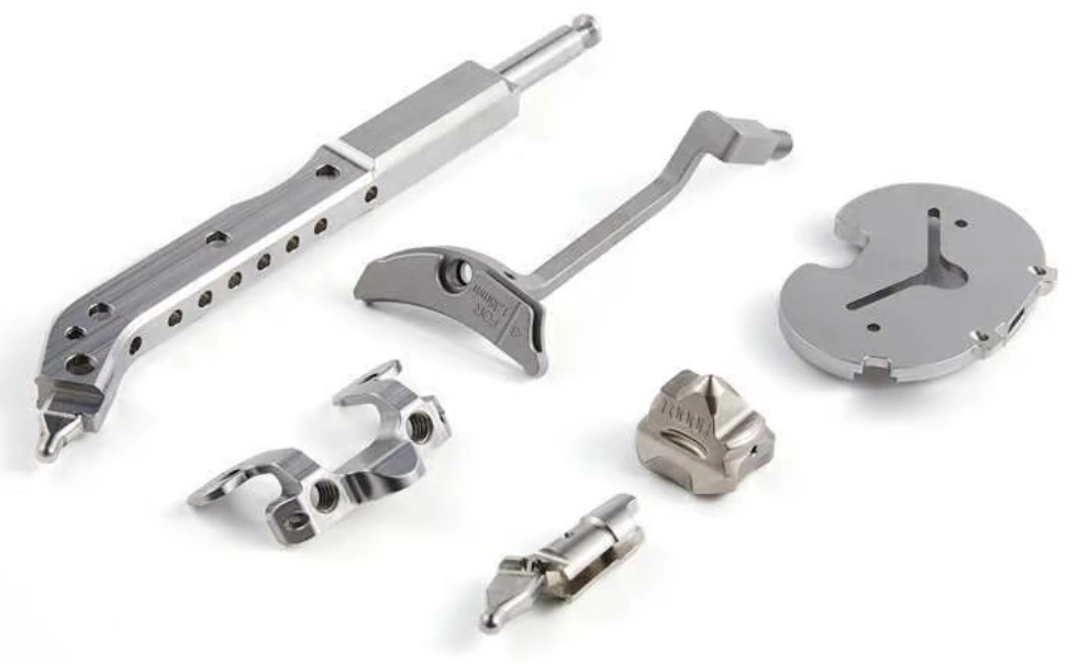 Various CNC-machined medical metal parts, including brackets, clips, and circular components