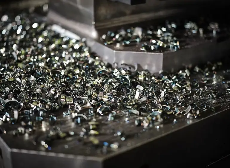 Metal chips and swarf accumulated on the CNC machine bed 