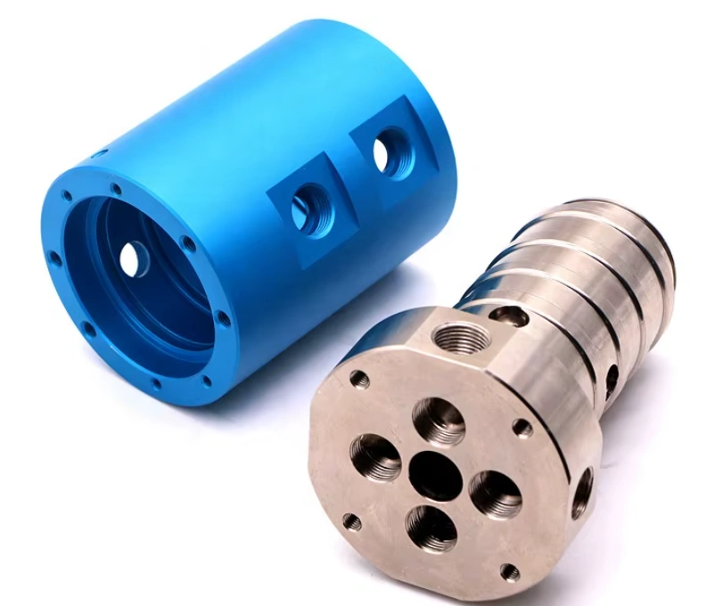 Blue and grey custom precision-machined parts with multiple threaded ports and holes.
