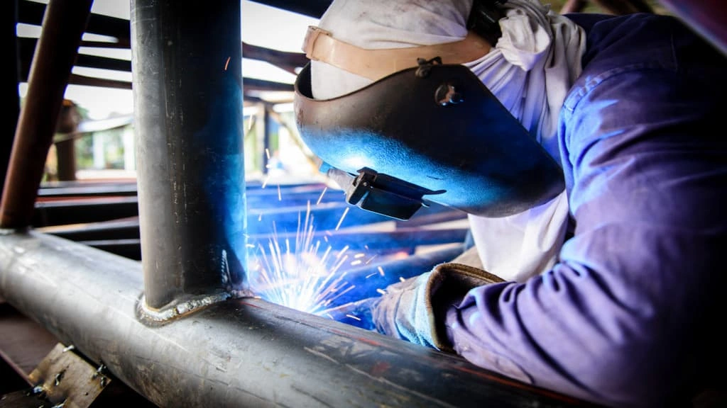 A mechanic performing a welding operation for the tubular truss structure 