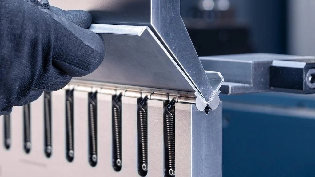 A close-up view of bending short flanges on a V-die