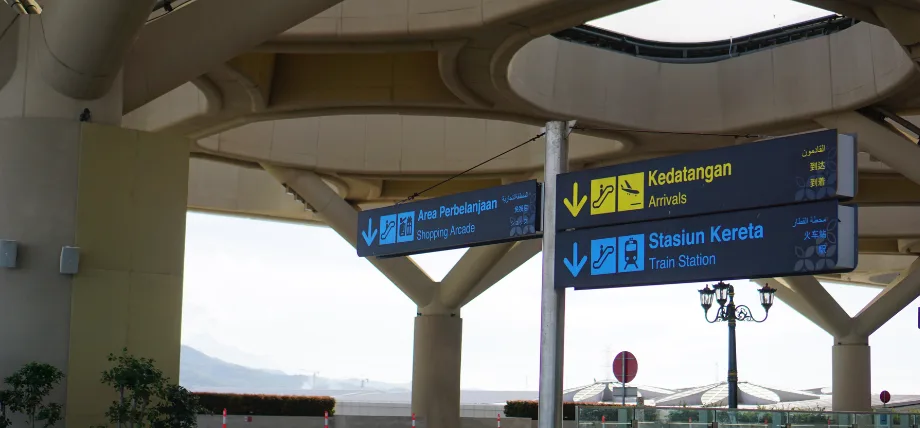 Overhead directional signs in an airport or transit hub
