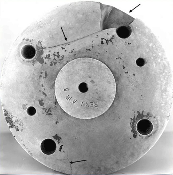 Broken circular die showing cracks and damage with multiple piercing holes