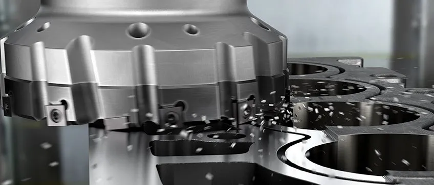 Industrial CNC milling head with carbide inserts machining an aluminum component with chips.