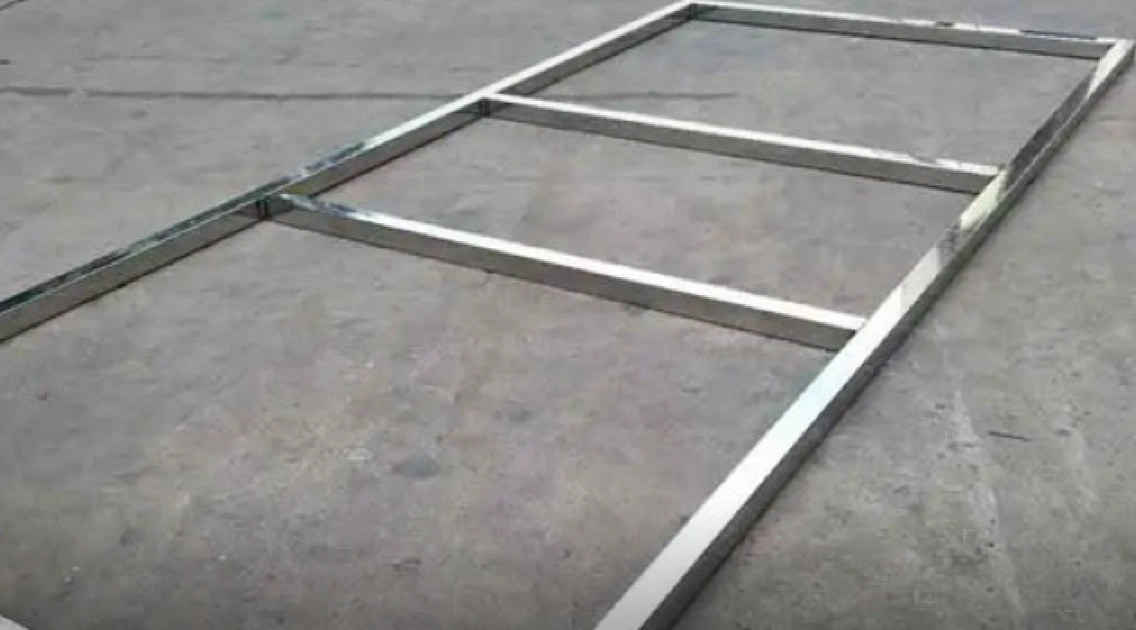 A polished metal frame standing on a plain background, its surface reflecting light evenly across the face