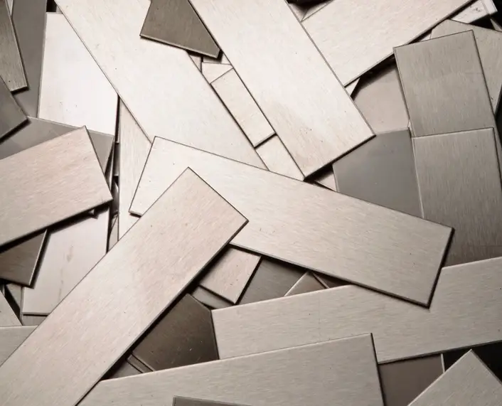 Assorted steel blanks in various rectangular and geometric shapes