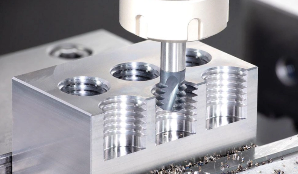 CNC miller cutting internal threads in a metal block 