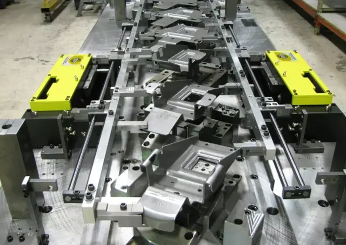 Multi-station transfer die with yellow automation components and formed metal cavities 