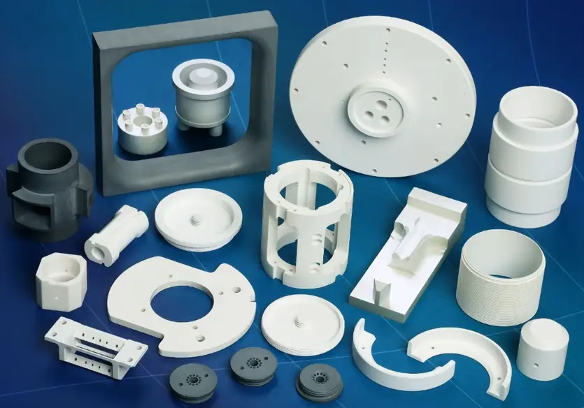 Collection of CNC-machined boron nitride ceramic components, including frames, discs, cylinders, brackets, and complex geometric shapes