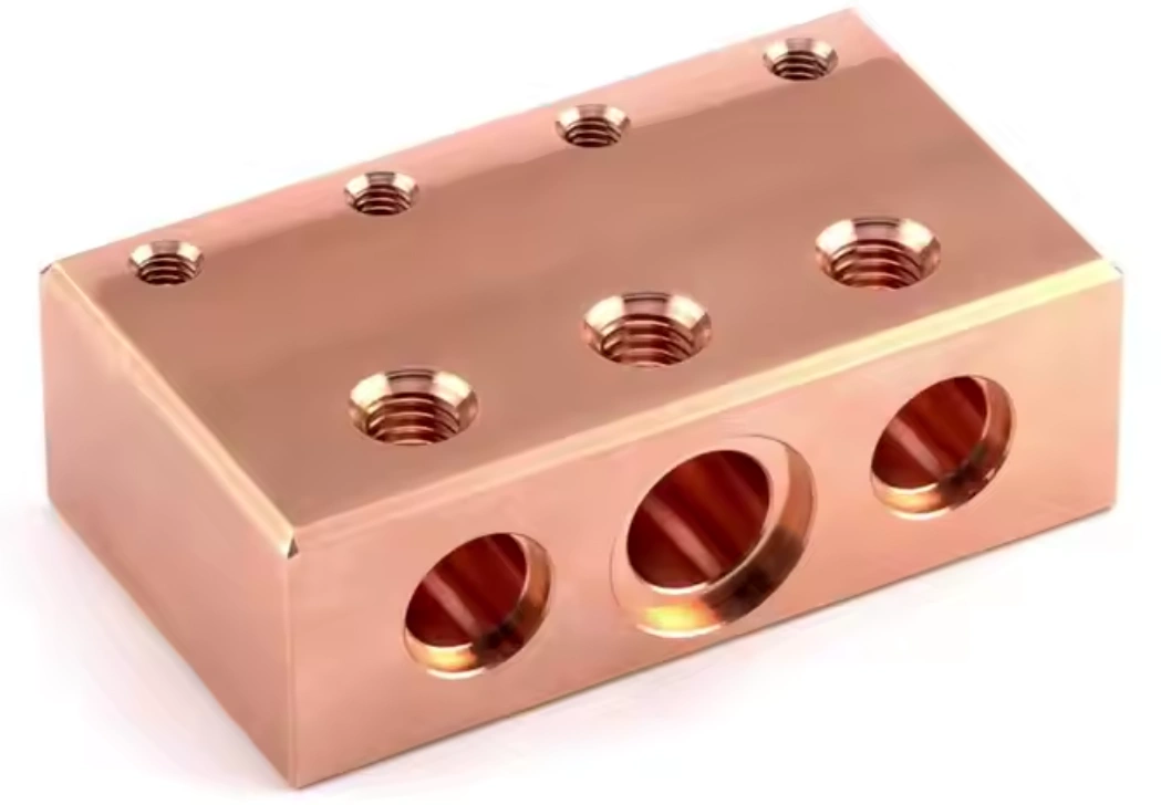 Red brass machined block component with threaded holes and chamfered bore openings