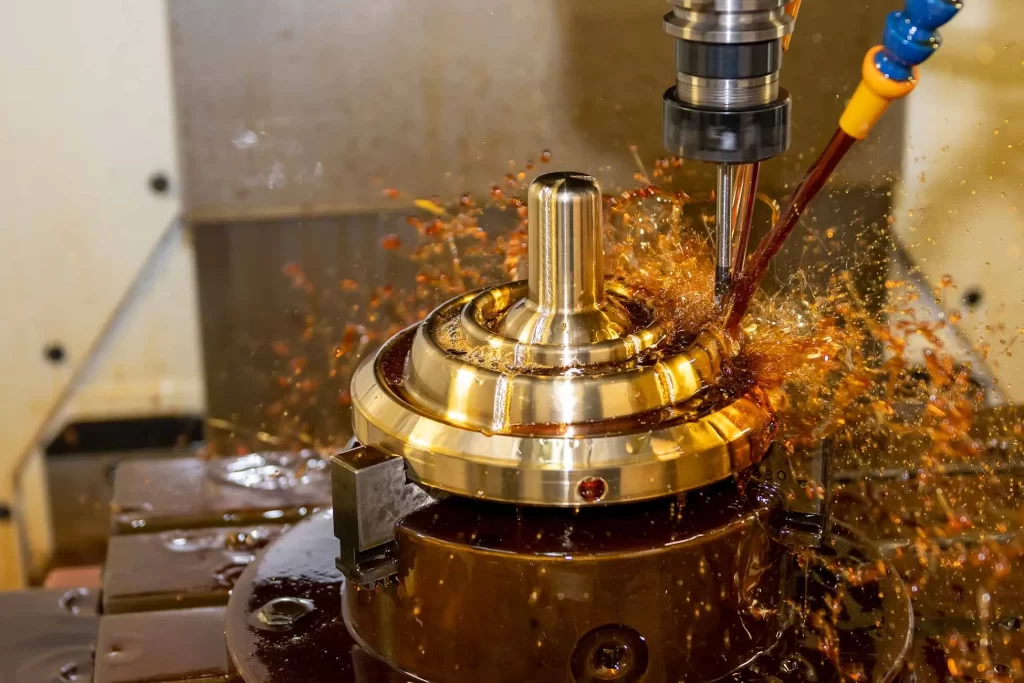 CNC machining cutting tool working on a workpiece of brass in the presence of coolant material