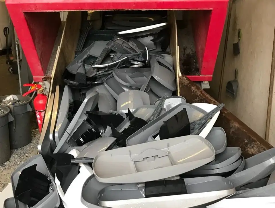 Discarded ABS plastic automotive bumpers and parts in a recycling container