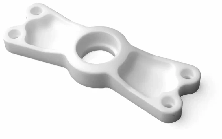 A machined white PTFE bracket for aircraft equipment, with drilled mounting holes