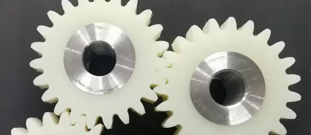 White UHMWPE sprockets with metal hubs displaying wear-resistant polyethylene material properties