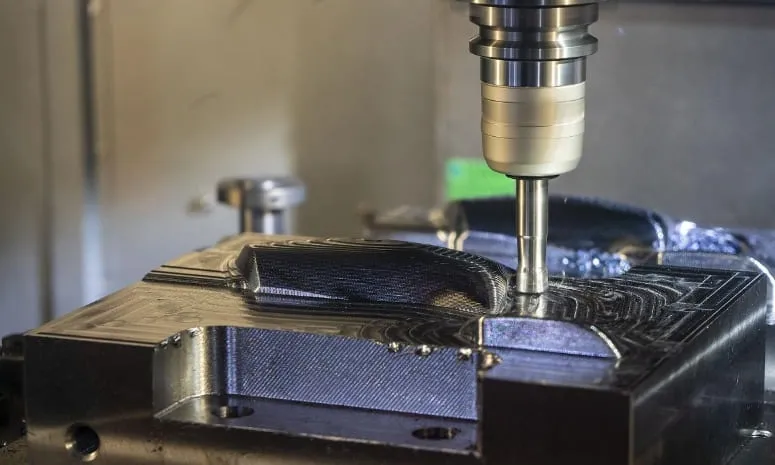 CNC milling machine cutting a metal mold or tooling component