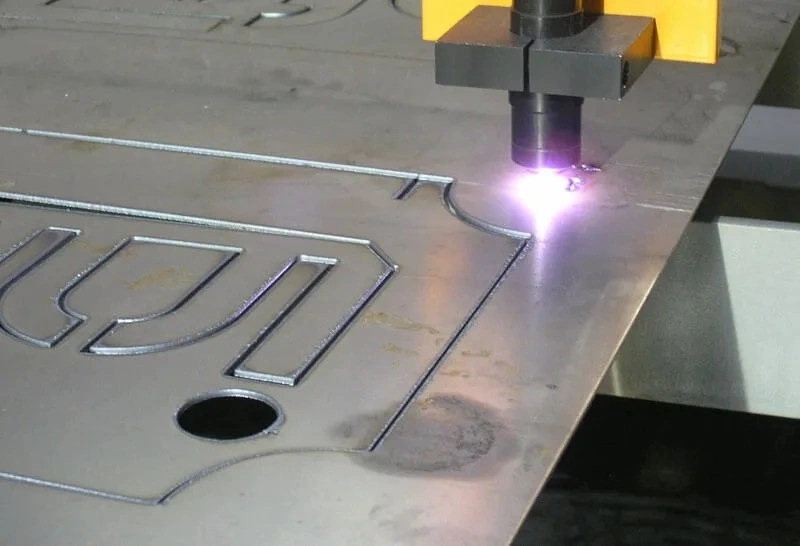 The image shows a thin aluminum sheet being plasma cut with a CNC torch.
