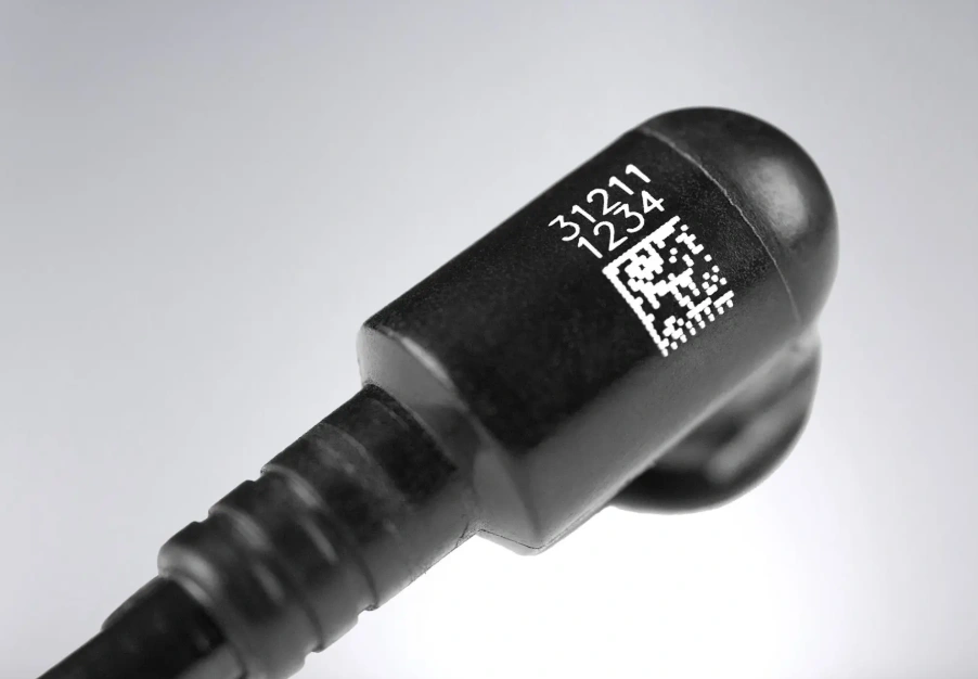 Black injection molded plastic connector with laser-etched QR code and alphanumeric identification markings