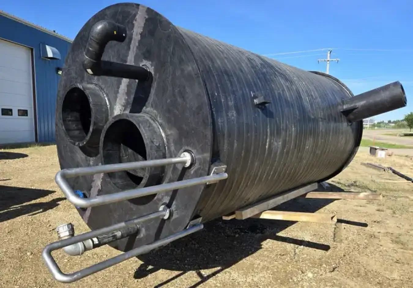 Large black HDPE storage tank with corrugated surface and multiple inlet/outlet ports