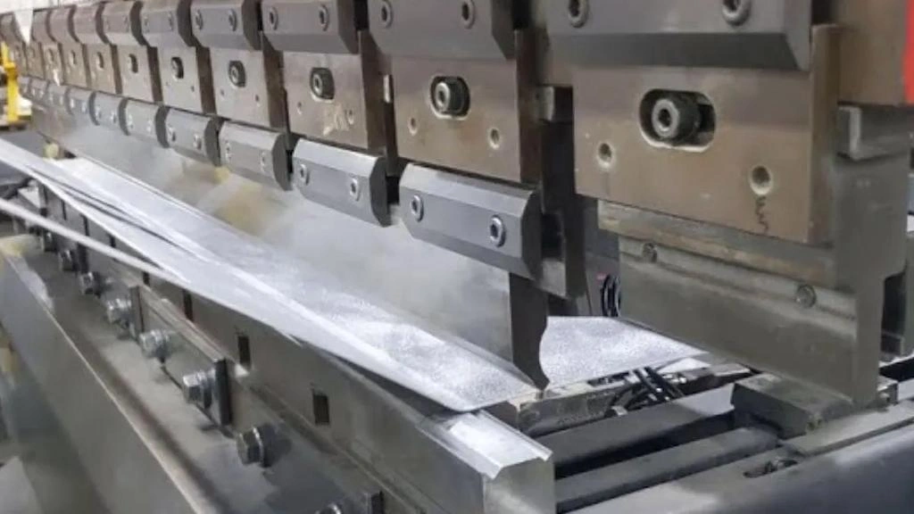 An illustration of the metal stamping process, showing progressive dies and punches 