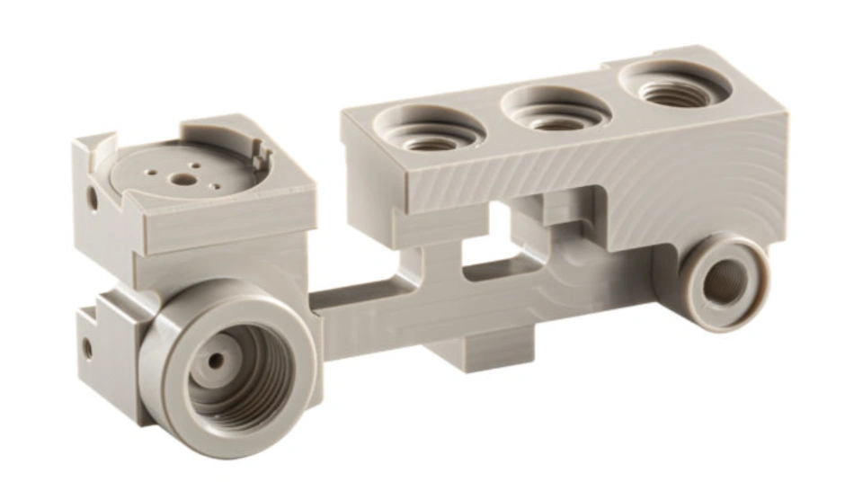 PEEK precision-machined medical device component with threaded ports and mounting features