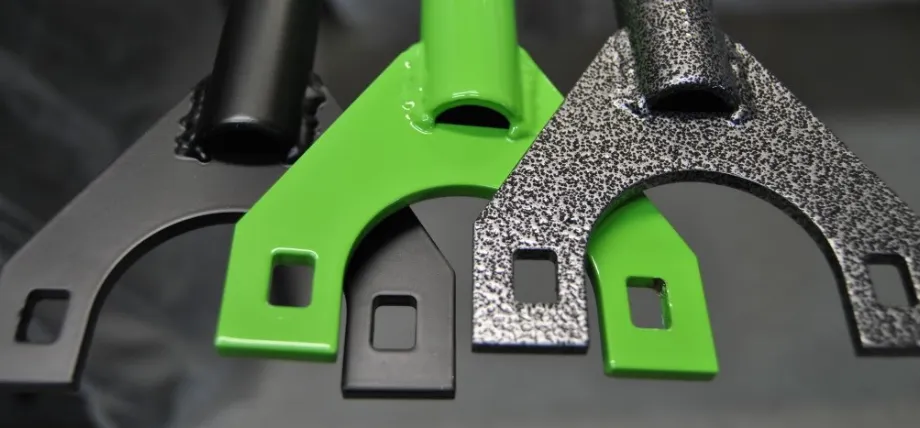 Close-up of three metal brackets showcasing different powder coating finishes; surface treatment options in OEM metal fabrication.