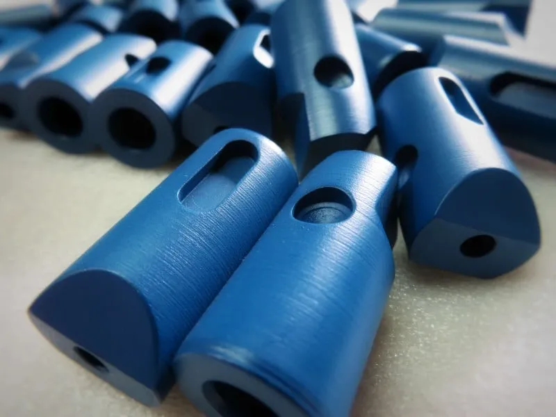 Blue anodized aluminum machined parts showing hard coat anodizing surface treatment for wear protection