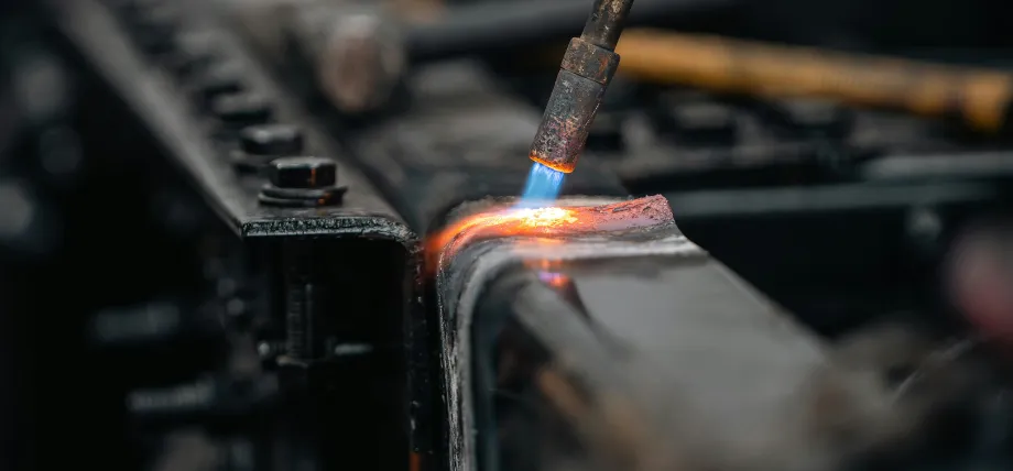 Close-up of a welding torch applying intense heat to join two metal components