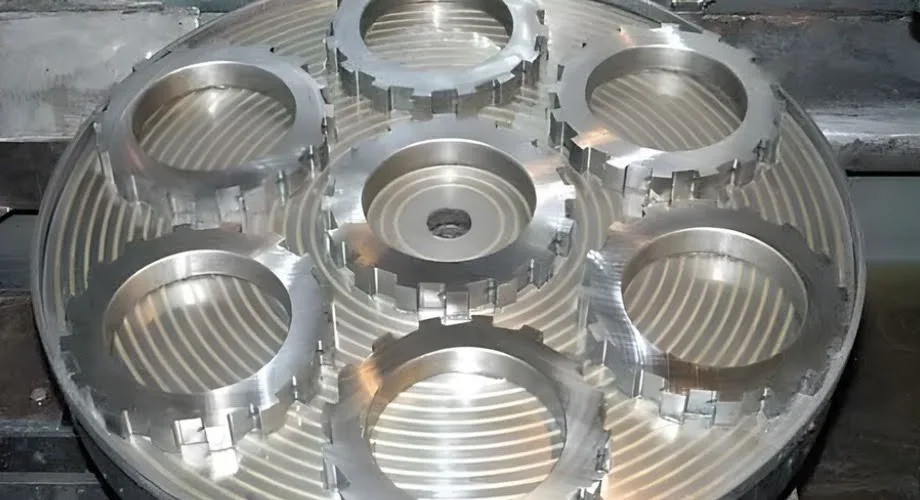 The image shows the top ground surface of seven gears placed over a rotary surface grinding table