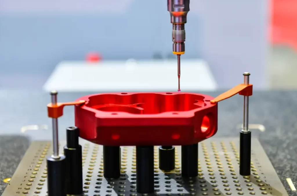 CMM probe performing dimensional inspection on a red part