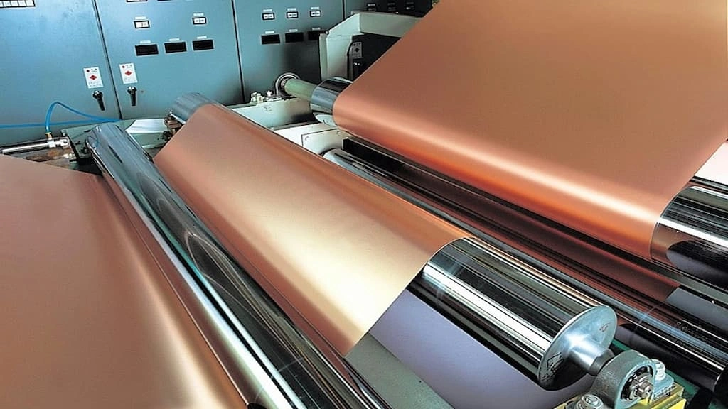 A close-up view of copper sheet bending using rollers
