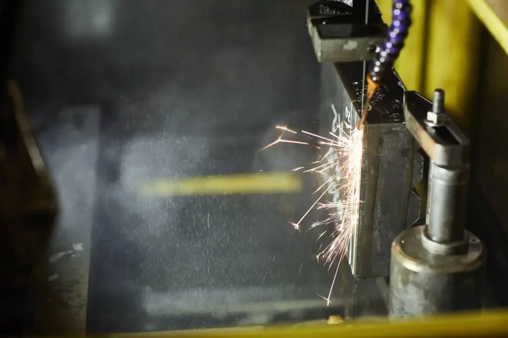 Close-up of the electrical discharge machining process used for shaping metal materials at the factory.