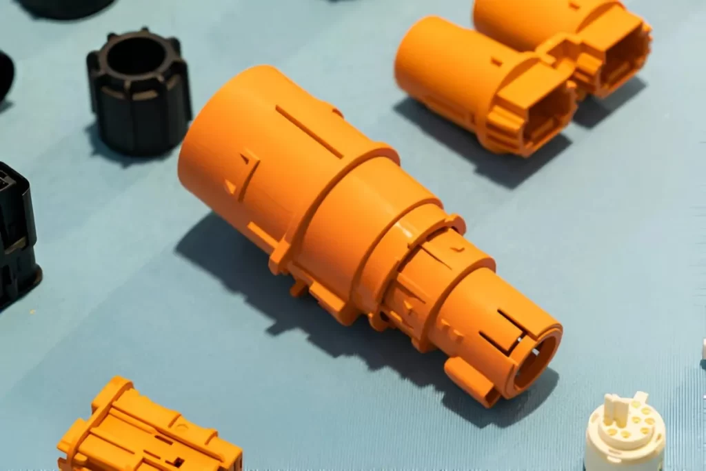 A close-up view of various aerospace parts made through injection molding. The parts show complex shapes, and lightweight plastic materials are used.