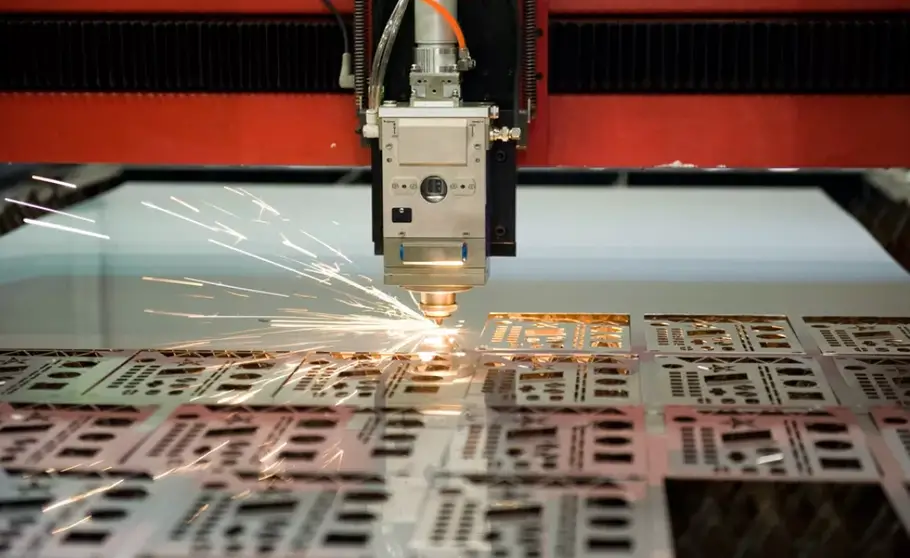 Laser cutting a metal sheet, creating sparks and potential burr formation