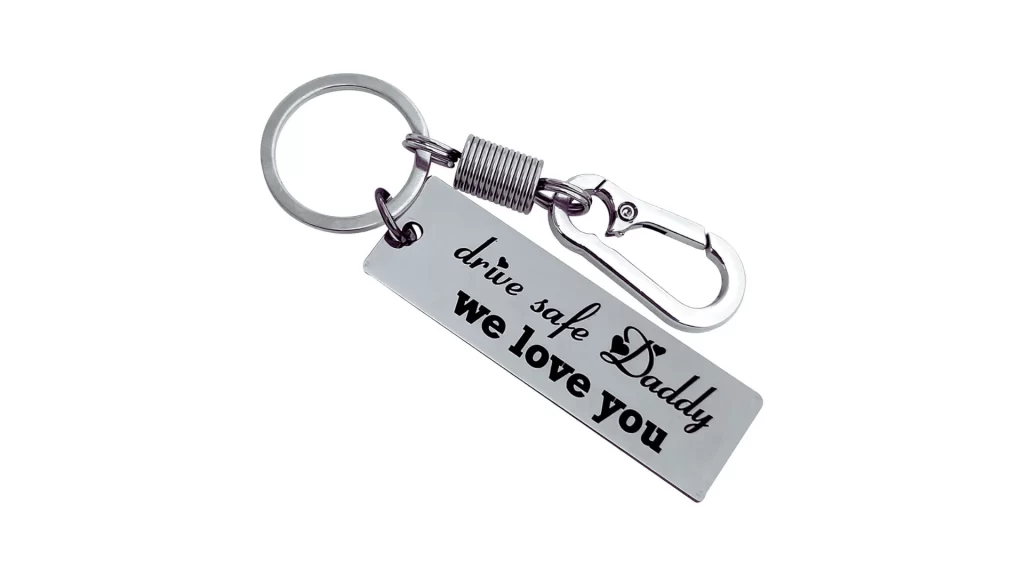 The image shows a black stainless steel keychain customized with laser engraving, designed as a gift from a daughter to her dad.