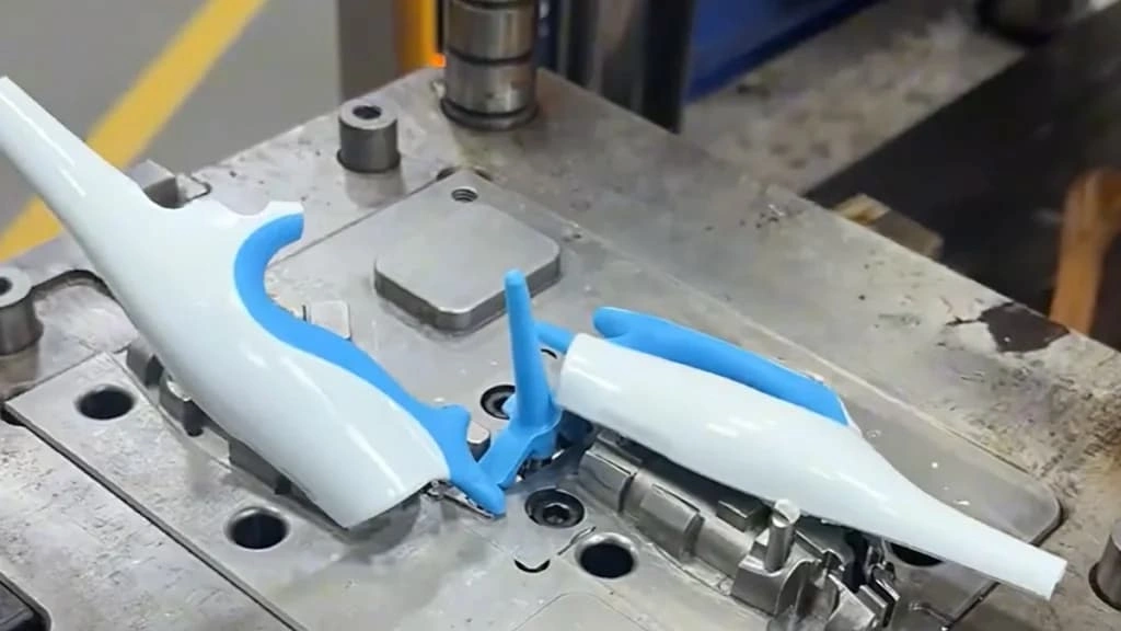 : A close-up view of ejecting a plastic overmolding part from an injection mold