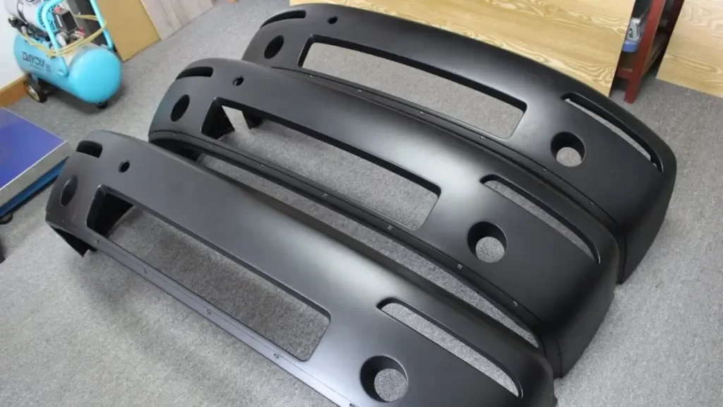 Multiple reaction molded parts with the same design are displayed on a table. The image shows consistent shapes and finishes.