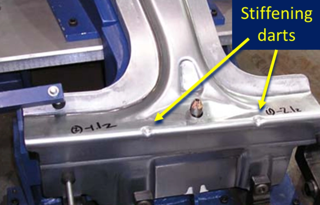 Stiffening darts on stamped aluminum automotive part