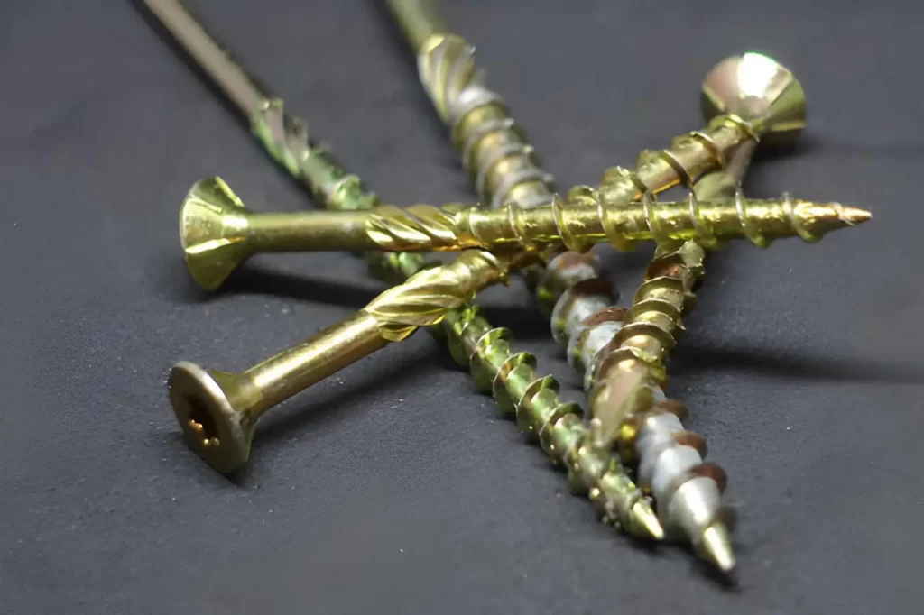 The image shows various types of steel screws finished with yellow zinc plating.