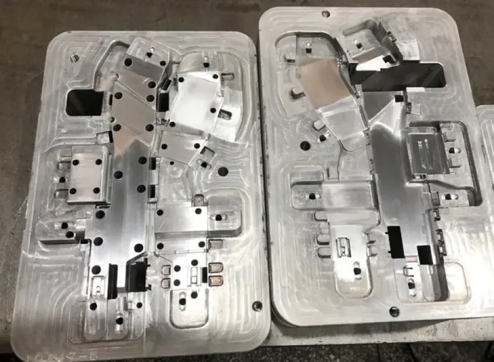 Open two-part aluminum injection mold showing complex cavity and core details