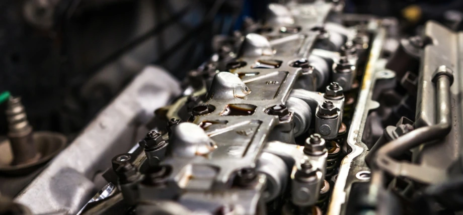 Close-up of torque-to-yield bolts securing an automotive cylinder head, demonstrating rivets vs bolts in high-precision applications.