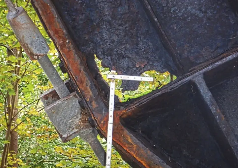 Heavily rusted bridge steel beam showing advanced corrosion and surface degradation