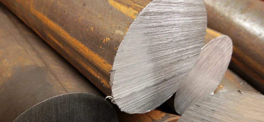 Close-up view of freshly cut ends of carbon steel round bars, displaying machining marks, mill scale.