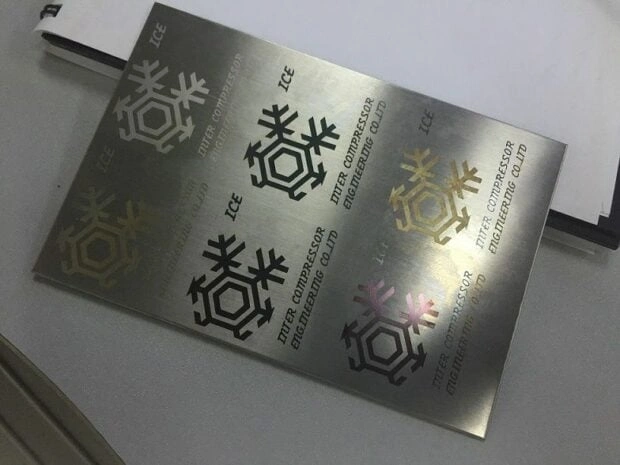 Stainless steel plate with laser-engraved snowflake logos in multiple colors