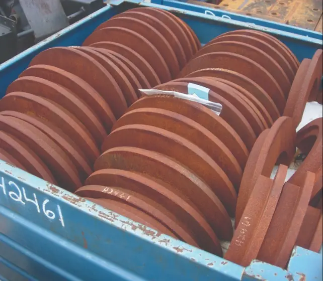 Stack of rusted iron disc components showing red rust layers