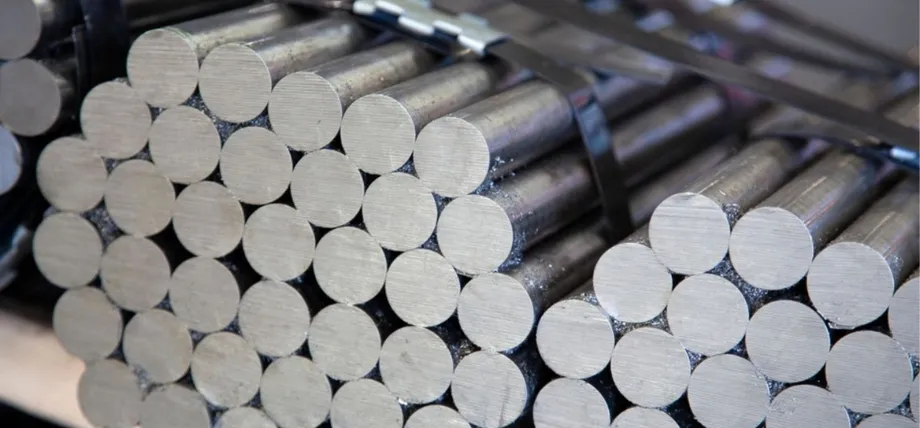 Multiple bundles of small-diameter aluminum bars secured tightly with black industrial metal strapping.