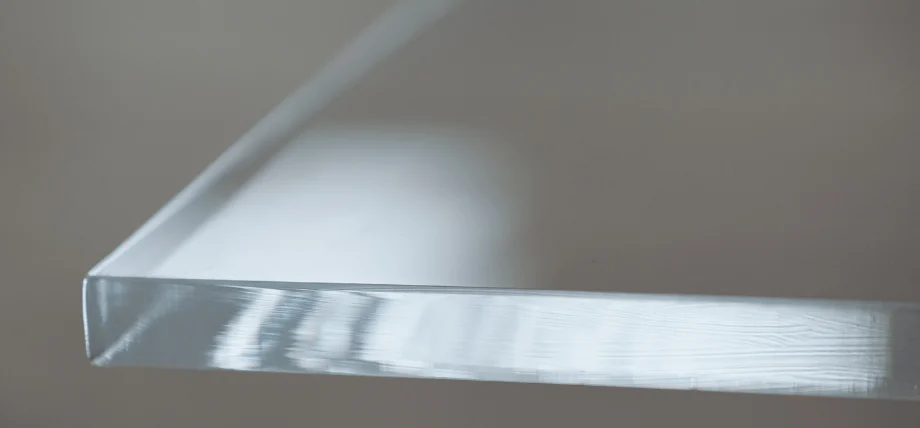 Edge view of a thick, transparent acrylic sheet with a smooth, polished finish.