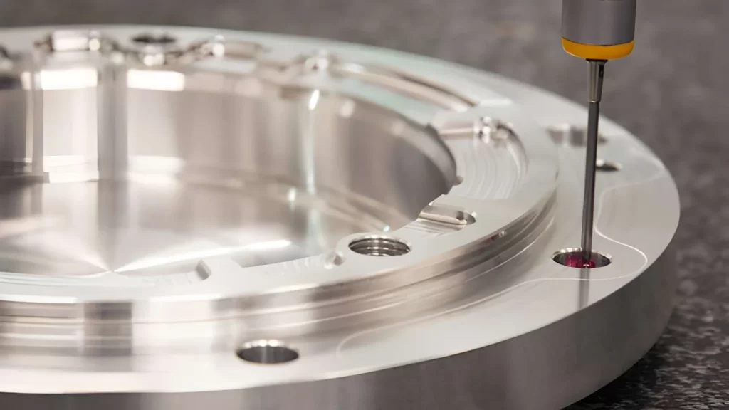 Round cylindrical component being worked on in a CNC machine, with the tool inserted into its hole.