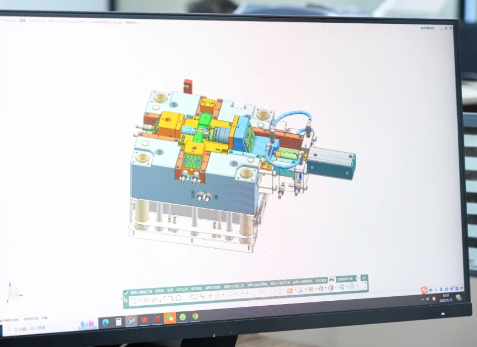 CAD software displaying a colorful 3D injection mold assembly design on a desktop monitor during DFM review