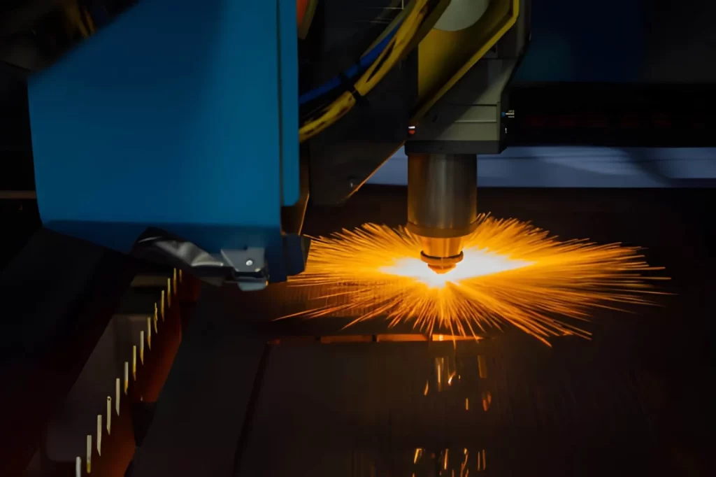 CNC fiber laser cutting machine working with sheet metal with sparks.